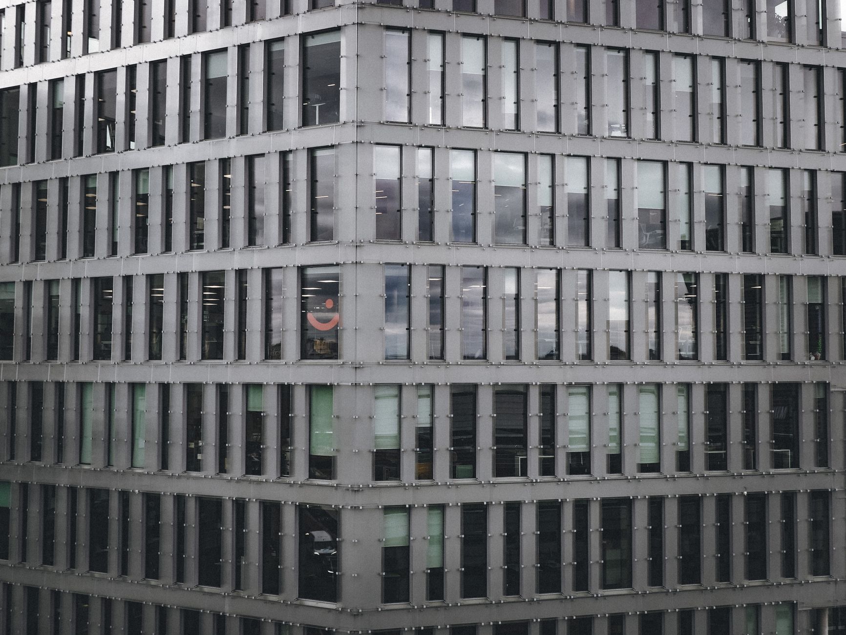 Exterior view of a modern highrise building with a pattern of glass windows