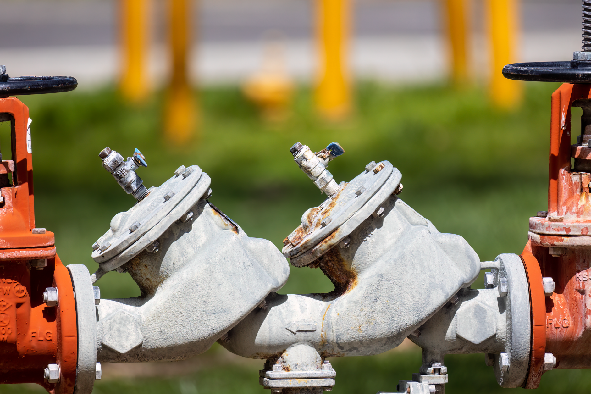 Detailed view of rusted industrial gas valves outdoors on a sunny day
