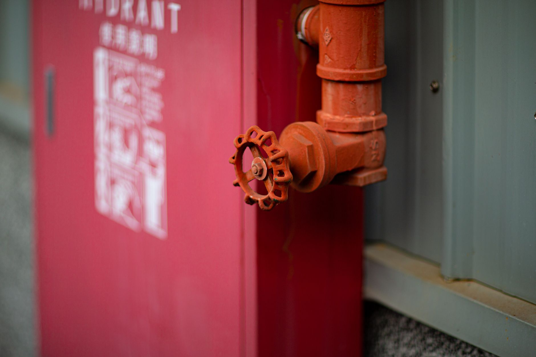 Detailed view of a red fire hydrant with valve in an urban setting in Taiwan